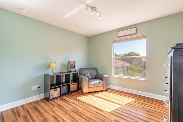 495 Venetian Villa Dr, New Smyrna Beach, FL 32168 - sitting room with track lighting, baseboards, and wood finished floors