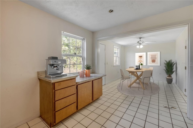 915 E 2nd Ave, New Smyrna Beach, FL 32169 - interior space featuring baseboards, light tile patterned floors, light countertops, and a ceiling fan