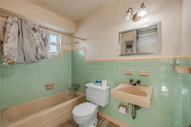 915 E 2nd Ave, New Smyrna Beach, FL 32169 - full bathroom with bathing tub / shower combination, toilet, a sink, wainscoting, and tile walls