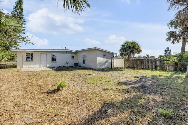 915 E 2nd Ave, New Smyrna Beach, FL 32169 - rear view of property with a yard, fence, and central AC unit