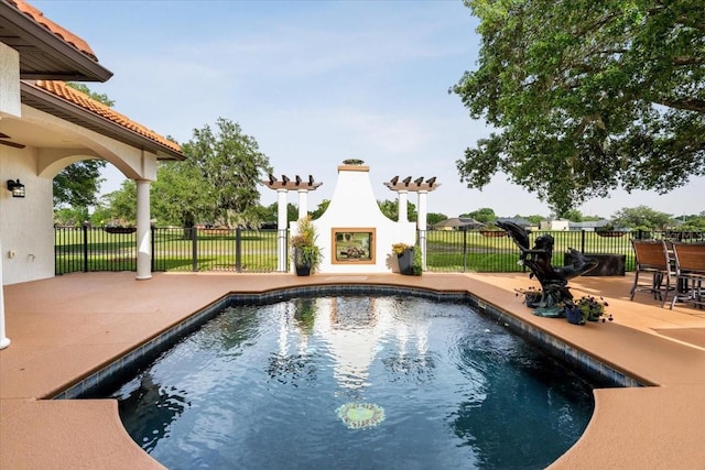 view of pool with a fenced in pool, a patio area, and a fireplace