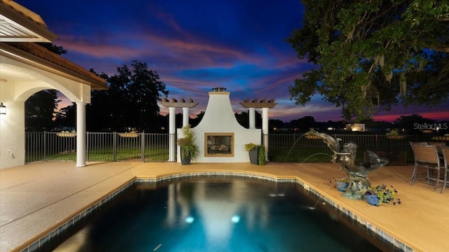 view of pool with a fenced in pool, an outdoor fireplace, and a patio area