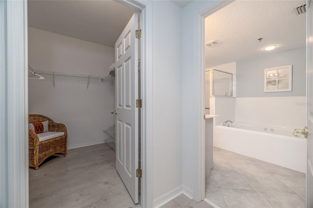 5300 S Atlantic Ave Unit 8-304, New Smyrna Beach, FL 32169 - bathroom featuring a bath, wood finished floors, visible vents, and a walk in closet