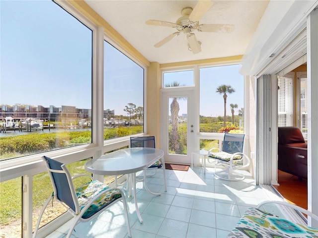 sunroom with tile patterned flooring and a water view