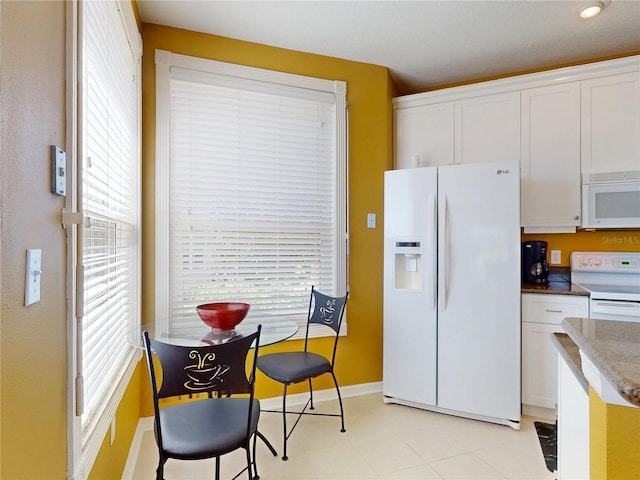 kitchen featuring plenty of natural light, white cabinetry, and white appliances