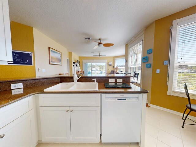 kitchen featuring a peninsula, a sink, white cabinetry, a ceiling fan, and dishwasher