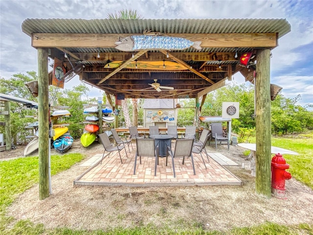 view of patio featuring outdoor dining area, a gazebo, and a ceiling fan