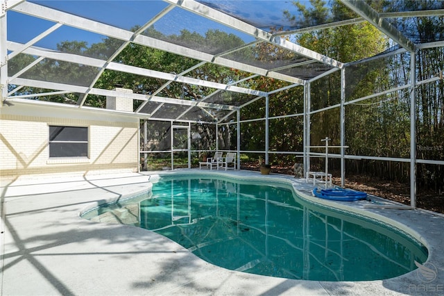 outdoor pool with glass enclosure and a patio