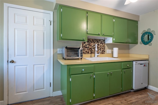 kitchen with dark wood finished floors, a toaster, dishwasher, a sink, and baseboards