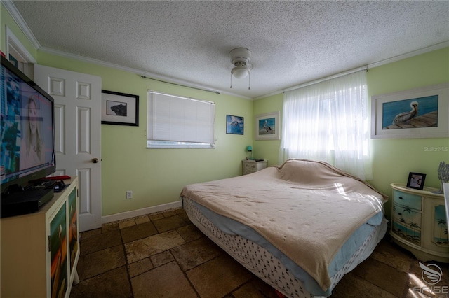 bedroom with stone tile flooring, a textured ceiling, a ceiling fan, and ornamental molding