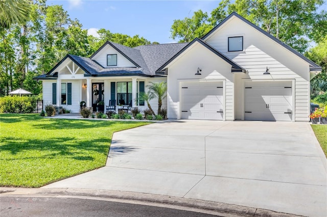 170 Live Oak Ct, New Smyrna Beach, FL 32168 - modern inspired farmhouse with a porch, roof with shingles, a front yard, an attached garage, and driveway