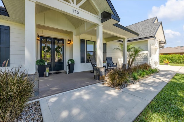 170 Live Oak Ct, New Smyrna Beach, FL 32168 - doorway to property featuring french doors, a porch, and a shingled roof