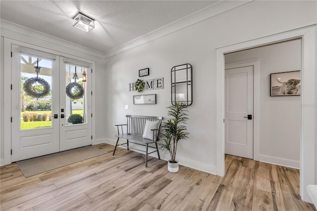 170 Live Oak Ct, New Smyrna Beach, FL 32168 - foyer with baseboards, ornamental molding, a textured ceiling, light wood finished floors, and french doors