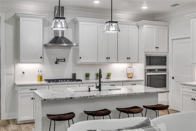 170 Live Oak Ct, New Smyrna Beach, FL 32168 - kitchen with white cabinets, a breakfast bar, appliances with stainless steel finishes, a sink, and backsplash