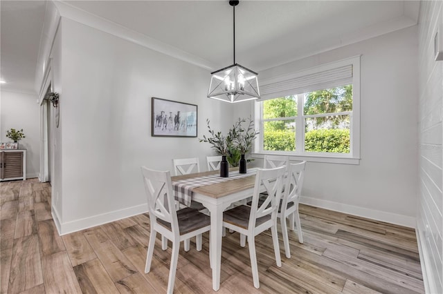 170 Live Oak Ct, New Smyrna Beach, FL 32168 - dining space with a chandelier, light wood finished floors, baseboards, and ornamental molding