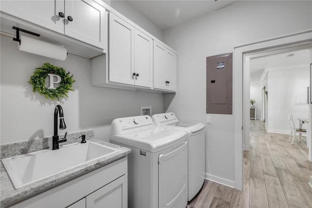 170 Live Oak Ct, New Smyrna Beach, FL 32168 - clothes washing area with light wood-type flooring, electric panel, washing machine and clothes dryer, a sink, and cabinet space