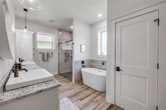 170 Live Oak Ct, New Smyrna Beach, FL 32168 - bathroom with a freestanding tub, a shower stall, visible vents, a sink, and wood finished floors