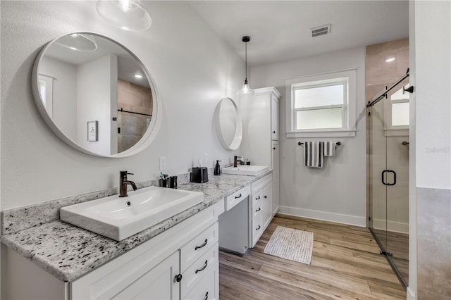 170 Live Oak Ct, New Smyrna Beach, FL 32168 - full bathroom with a sink, double vanity, a stall shower, and wood finished floors