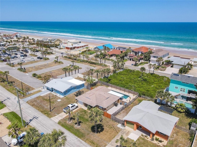 birds eye view of property with a water view and a beach view