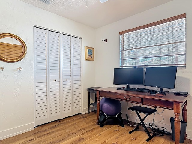 office area with baseboards and light wood finished floors