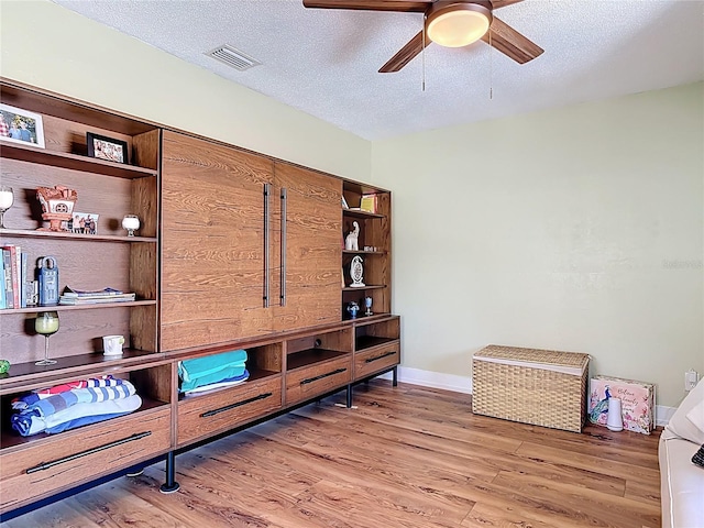 interior space with visible vents, a ceiling fan, and a textured ceiling