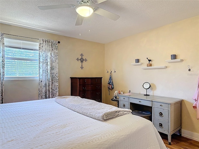 bedroom with a textured ceiling, a ceiling fan, and wood finished floors
