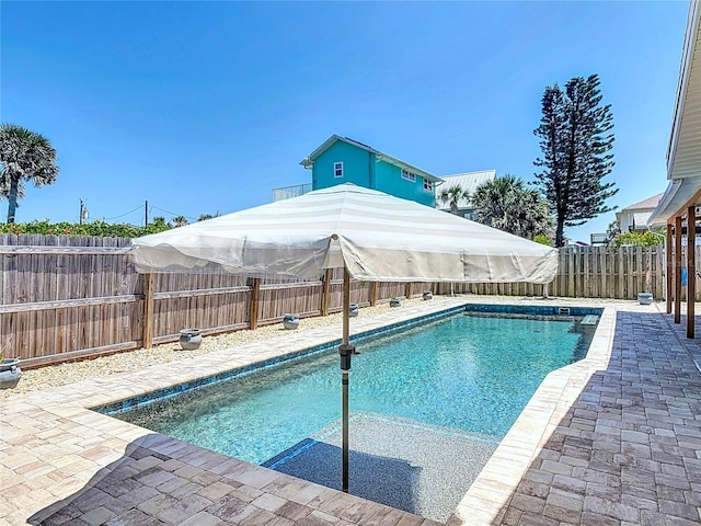 view of pool featuring a fenced backyard, a fenced in pool, and a patio area