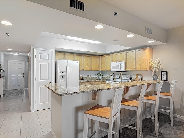 kitchen featuring light stone counters, white appliances, baseboards, a peninsula, and visible vents