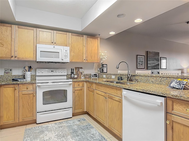 kitchen with recessed lighting, light stone counters, light tile patterned floors, a sink, and white appliances