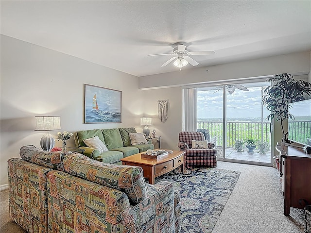 living area featuring ceiling fan and carpet