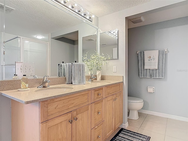bathroom featuring tile patterned floors, a sink, a textured ceiling, and visible vents
