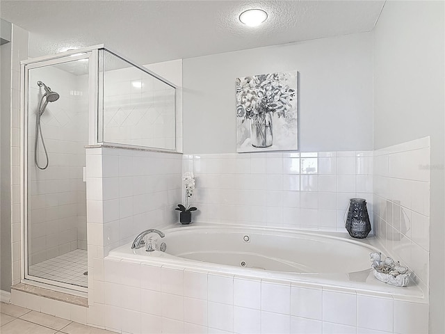 bathroom featuring a whirlpool tub, a textured ceiling, tile patterned floors, and a stall shower