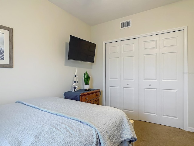 carpeted bedroom featuring visible vents and a closet