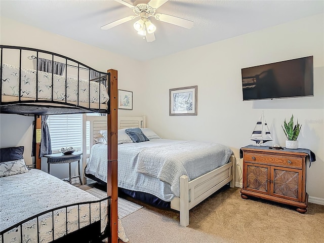 bedroom with a ceiling fan, baseboards, and light colored carpet