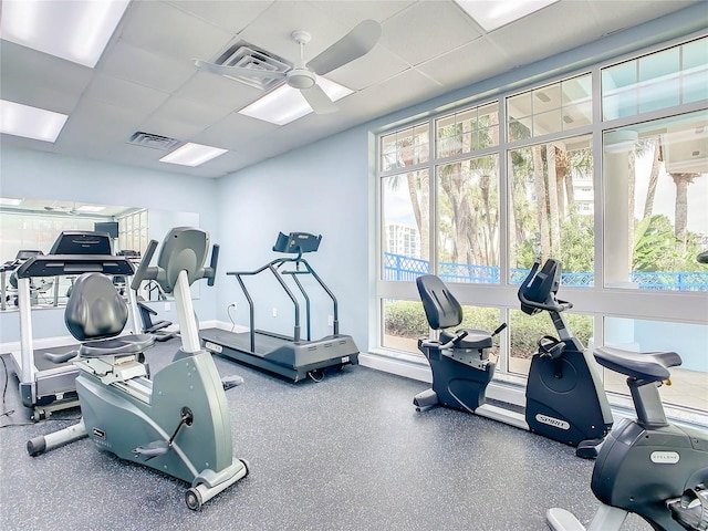 gym with a paneled ceiling, a ceiling fan, and visible vents