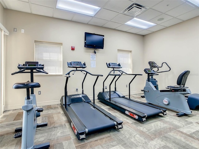 workout area with baseboards, visible vents, carpet flooring, and a paneled ceiling