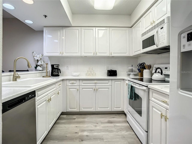5300 S Atlantic Ave Unit 10-205, New Smyrna Beach, FL 32169 - kitchen with a sink, light wood-type flooring, tasteful backsplash, white appliances, and white cabinets