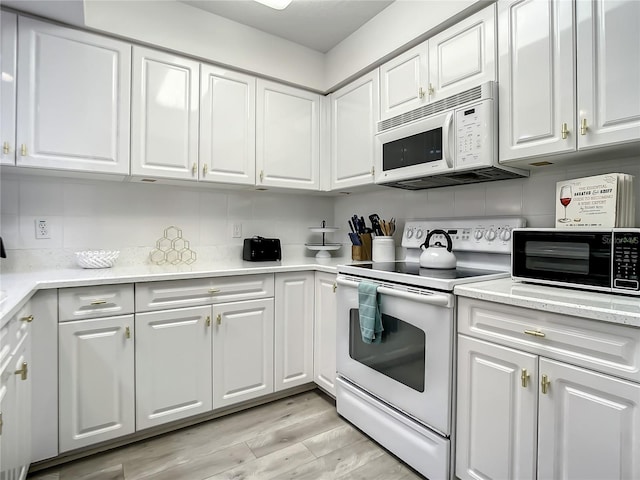 5300 S Atlantic Ave Unit 10-205, New Smyrna Beach, FL 32169 - kitchen featuring white cabinetry, white appliances, light wood-type flooring, and backsplash