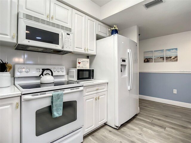 5300 S Atlantic Ave Unit 10-205, New Smyrna Beach, FL 32169 - kitchen featuring white cabinetry, visible vents, white appliances, and light countertops