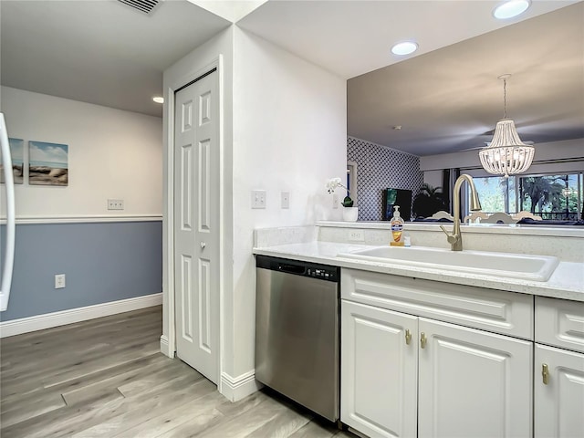 5300 S Atlantic Ave Unit 10-205, New Smyrna Beach, FL 32169 - kitchen with stainless steel dishwasher, white cabinets, a sink, a chandelier, and light wood-type flooring
