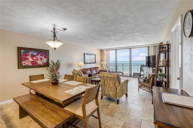 4139 S Atlantic Ave Unit A504, New Smyrna Beach, FL 32169 - dining room with a wall of windows and stone finish floor