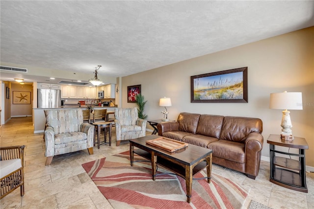 4139 S Atlantic Ave Unit A504, New Smyrna Beach, FL 32169 - living area with a textured ceiling, visible vents, and baseboards