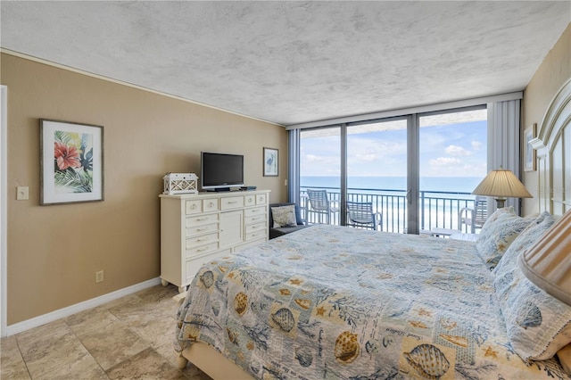 4139 S Atlantic Ave Unit A504, New Smyrna Beach, FL 32169 - bedroom featuring a wall of windows, a textured ceiling, baseboards, and access to outside