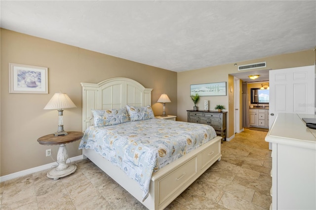 4139 S Atlantic Ave Unit A504, New Smyrna Beach, FL 32169 - bedroom featuring baseboards, ensuite bathroom, visible vents, and stone finish floor