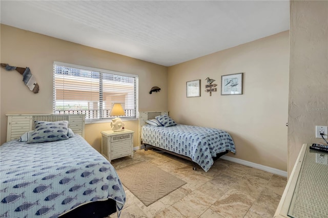 4139 S Atlantic Ave Unit A504, New Smyrna Beach, FL 32169 - bedroom featuring baseboards and stone finish floor