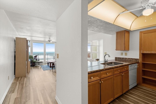 5201 S Atlantic Ave Unit 708A, New Smyrna Beach, FL 32169 - kitchen with a sink, white dishwasher, ceiling fan, brown cabinetry, and a textured ceiling