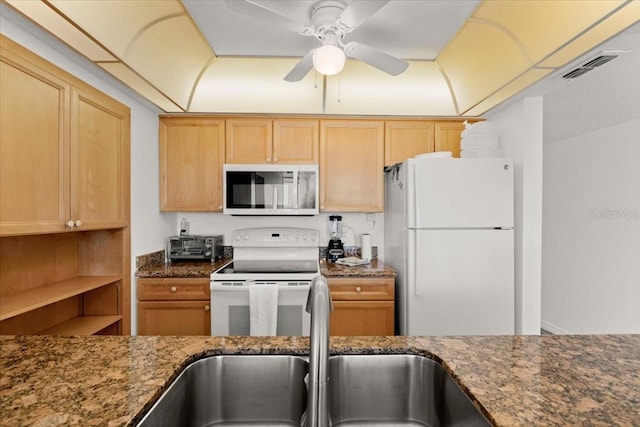 5201 S Atlantic Ave Unit 708A, New Smyrna Beach, FL 32169 - kitchen with white appliances, a sink, dark stone counters, a ceiling fan, and light brown cabinetry