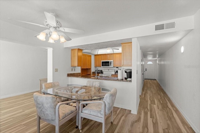 5201 S Atlantic Ave Unit 708A, New Smyrna Beach, FL 32169 - dining room with light wood-style floors, baseboards, and ceiling fan