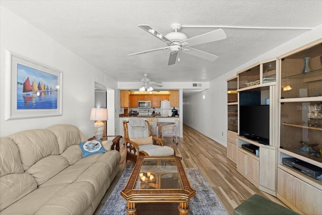 5201 S Atlantic Ave Unit 708A, New Smyrna Beach, FL 32169 - living area with light wood finished floors, ceiling fan, and a textured ceiling