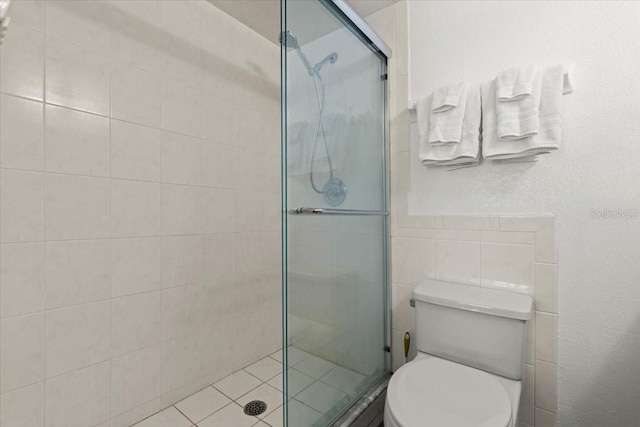 5201 S Atlantic Ave Unit 708A, New Smyrna Beach, FL 32169 - full bathroom featuring a stall shower, toilet, and tile walls